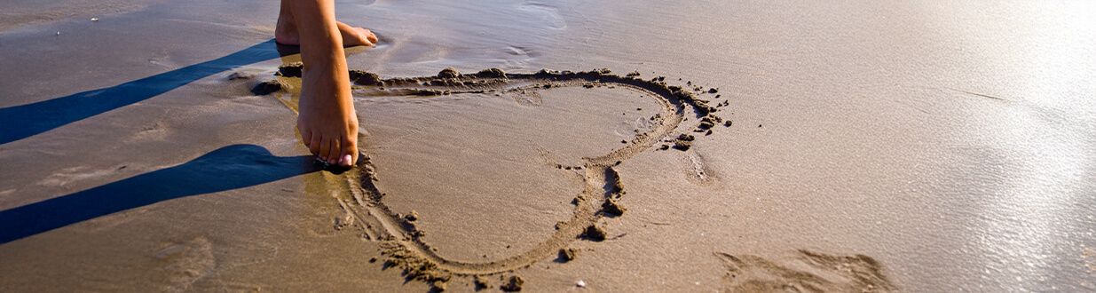 valentines-day-drawing-hearts-on-beach-sand